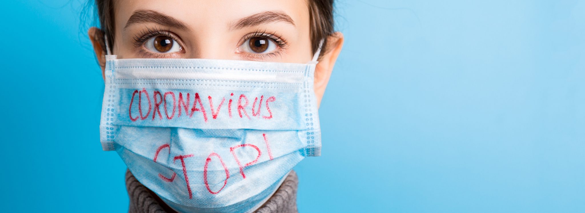 Девушка в маске медицинской на голубом фоне
